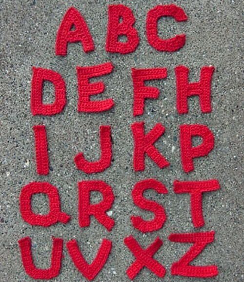 the letters and numbers are made out of red thread on concrete flooring, which has been placed together to form an alphabet