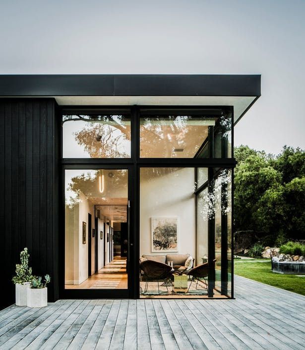 the inside of a house with glass doors and wooden decking on top of it