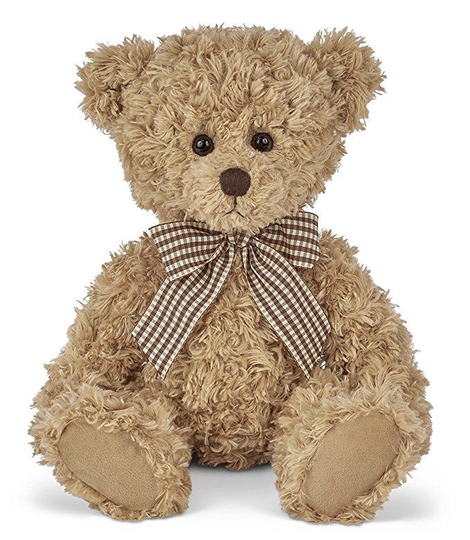 a brown teddy bear sitting on top of a white surface with a bow around it's neck