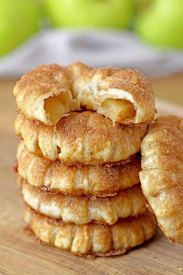 a stack of apple pies sitting on top of a wooden table