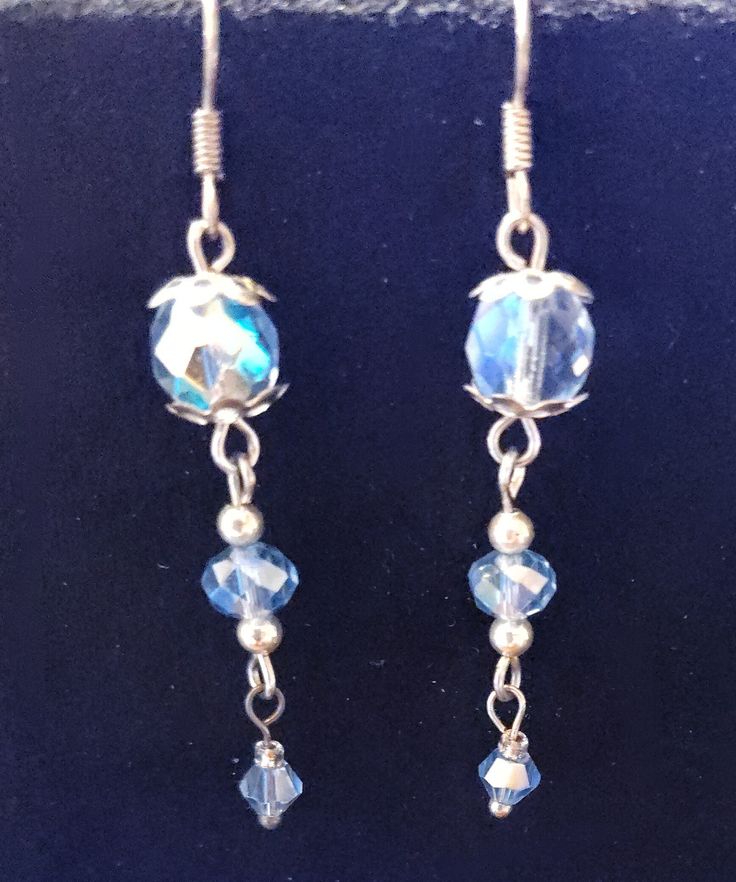 A beautiful pair of silvertone blue crystal earrings. They are silvertone with silver bead caps and spacer beads. As is with all of my jewelry, this is a handmade one-of-a-kind pair of earrings. Thank you for looking and happy shopping. Beaded Sterling Silver Crystal Earrings, Silver Czech Glass Jewelry With Matching Earrings, Blue Dangle Earrings With Silver Beads, Blue Crystal Earrings With Dangling Beads For Gift, Silver Crystal Beaded Earrings For Gift, Costume Jewelry Crystal Dangle Earrings, Dangle Earrings With Czech Glass Faceted Beads, Beaded Sterling Silver Dangle Crystal Earrings, Silver Round Bead Costume Earrings