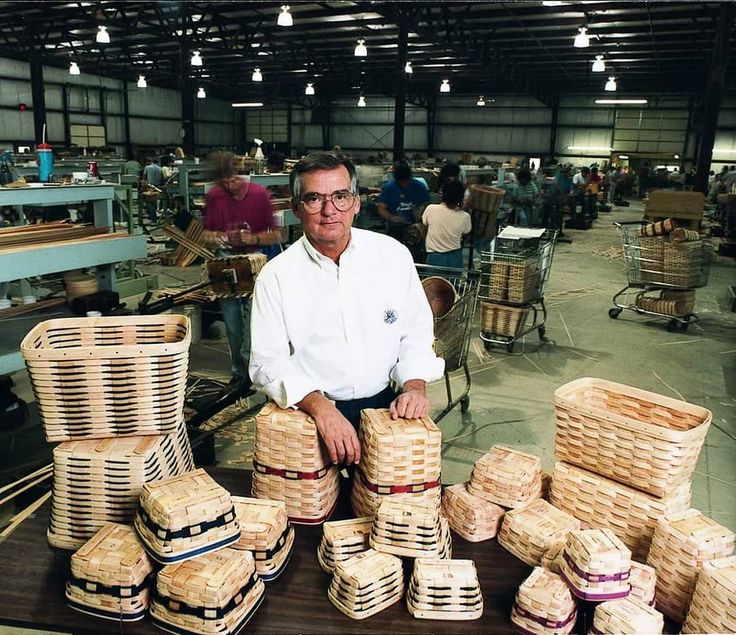 a man sitting in front of stacks of baskets