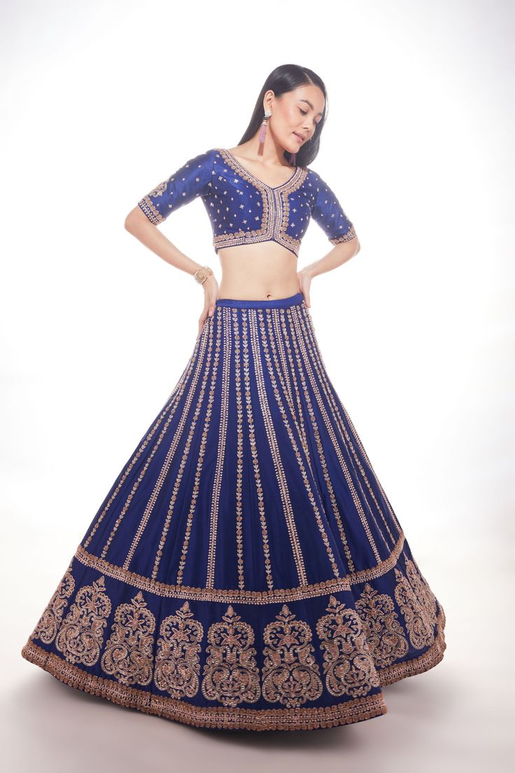 Blue silk lehenga with intricate motifs at the base and delicate lines of zardozi paired with matching blouse and net dupatta with thick main border and thinner borders on 3 sidesFrom Chamee and Palak 's The Wedding Edit collectionDELIVERY TIMEPlease allow 8-12 weeks for your outfit to arrive.FABRIC DETAILSSilk And NetProfessional cleaning only. Blue Silk Lehenga With Intricate Embroidery, Traditional Blue Gown With Zari Work, Elegant Silk Thread Lehenga With Dori Work, Blue Art Silk Gown With Traditional Drape, Elegant Silk Lehenga With Dori Work, Royal Blue Sharara With Intricate Embroidery For Festive Occasions, Blue Anarkali Silk Lehenga, Designer Silk Lehenga With Cutdana, Blue Silk Anarkali Lehenga