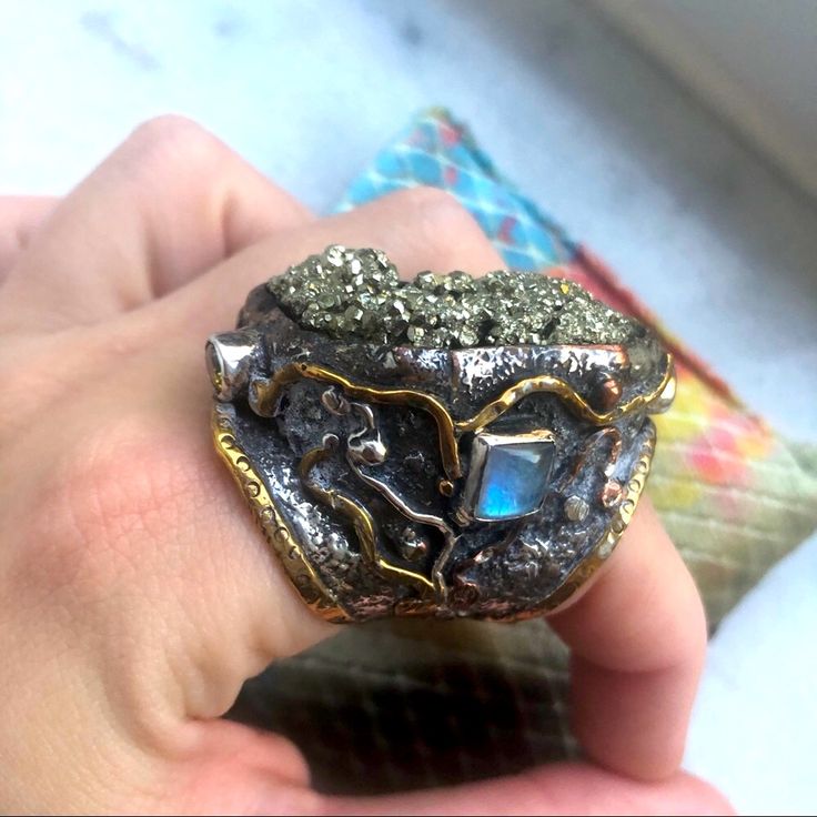 What A Stunning Statement This Ring Makes! Marked David Godinez For San Miguel Artisan Who Created It Marked 925 For Sterling Silver Large Pyrite Center Surrounded By Crown Of 2 Square Moonstones And 2 Citrines Has A Brutalist Style, Condition Is Euc, Barely Worn & Kept Safe. Will Be Cleaned Before Sent Like All Jewelry And Comes In A Gift Box. Measures 8-9 On Ring Sizer. Very Comfortable To Wear & Well Made If You Have Any Questions Please Ask Unique Opal Ring With Moonstone, Fusion Style Moonstone Gemstone Jewelry, Fusion Style Moonstone Ring Gift, Handmade Celestial Silver Opal Ring, Silver Multi-stone Opal Ring As Gift, Multi-stone Moonstone Opal Ring For Gifts, Moonstone Multi-stone Opal Ring As Gift, Unique Sterling Silver Moonstone Ring, Artisan Moonstone Ring For Healing