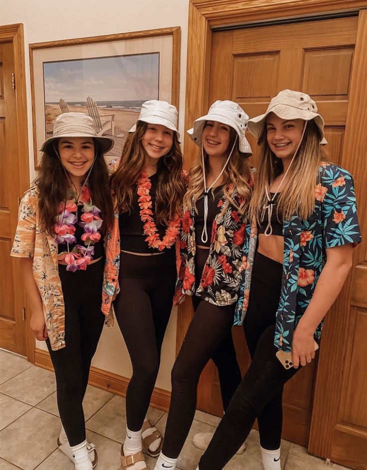 three girls in matching outfits standing next to each other with hats on their heads and one girl wearing black leggings