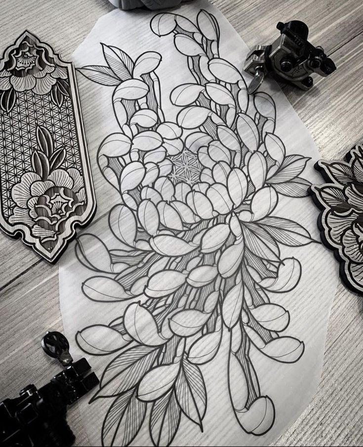 some black and white flowers are on the table next to an inking machine, which is