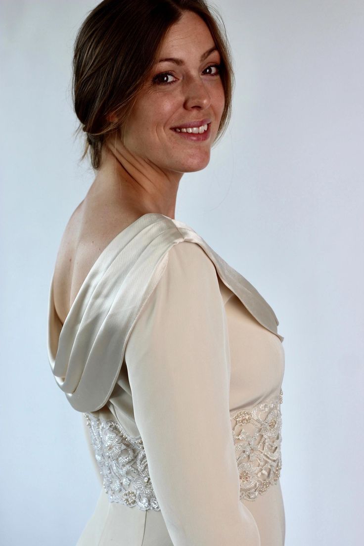 a woman in a white dress smiling for the camera