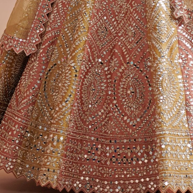 Step into effortless elegance with the Rust and Mustard Silk Lehenga, a perfect style for Mehendi celebration. This opulent lehenga radiates tradition featuring meticulous gota and mirrorwork that capture the light with every movement. The classic rust blouse is adorned with exquisite embroidery, complementing the vibrant mustard gold dupatta that cascades effortlessly, adding a touch of grace to your silhouette. Perfectly blending craftsmanship and style, this embroidered Lehenga is more than j Mirror Lehenga, Gold Dupatta, Rust Blouse, Gold Lehenga, Vacuum Storage, Embroidered Lehenga, Grace To You, Indian Wedding Wear, Silk Lehenga