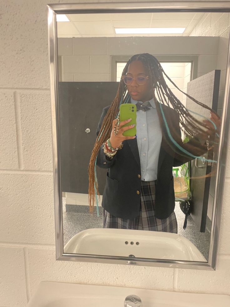 a person taking a selfie in a mirror with dreadlocks and a cell phone