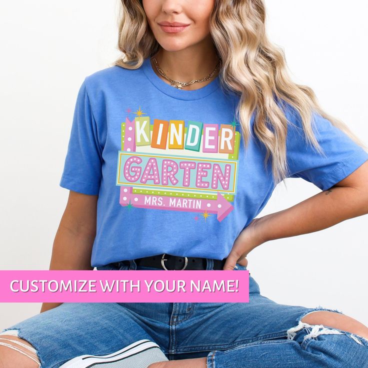 Whether you're looking for a fun and unique gift for a teacher friend or want to treat yourself to something special for the first day of school, this Kindergarten Teacher shirt is sure to bring a smile to your face and to your students'. Find more back to school shirts, sweatshirts and gifts for your favorite Kinder Teacher here: https://www.etsy.com/shop/JaxGraphicTees?search_query=kindergarten All of our adult t-shirts are Bella + Canvas 3001 Unisex shirts. They are a super soft fabric that w Fun Letter Print Shirt For Teacher Appreciation, Cute T-shirt With Name Print For Teacher Appreciation, School Spirit Short Sleeve Shirt For Teacher Appreciation, Fun Custom Print T-shirt For Teacher Appreciation, Back To School Spirit Shirt For Teacher Appreciation, School Spirit Shirt With Name Print For Teacher Appreciation, Fun Back To School Shirt With Letter Print, Fun Back-to-school Shirt With Letter Print, Fun Letter Print Shirt For Back To School