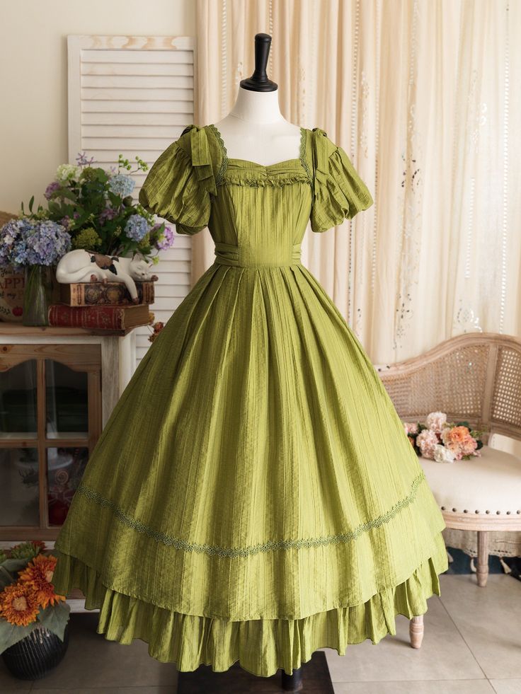 This price includes a dress and a green bowknot hairclip (not for sale).  Embrace timeless elegance with this enchanting Olive Green Puff Sleeves Classic Lolita Princess Tea-Length Dress. Designed for the true Lolita aficionado, this dress features delicately puffed sleeves and a flattering tea-length skirt that exudes sophistication and charm. The back boasts a comfortable shirring detail, ensuring a perfect fit for all body types. Whether you're attending a tea party, a cosplay event, or simply indulging in a whimsical day out, this dress will make you feel like royalty. The rich olive green hue adds a touch of nature-inspired beauty to your Lolita wardrobe, making it a versatile and must-have piece.   	 		 			Size 			S 			M 			L 			XL 			2XL 		 		 			Bust 			82-90 			88-96 			94-102 Fitted Green Victorian Dress With Ruffles, Green Puff Sleeve Dress For Wedding, Green Puff Sleeve Dress In Cottagecore Style, Green Vintage Victorian Dress With Ruffles, Vintage Green Puff Sleeve Dress, Elegant Green Vintage Dress With Ruffles, Vintage Green Dress With Puff Sleeves, Elegant Green Vintage Dress For Garden Party, Green Vintage Dress With Ruffles For Garden Party