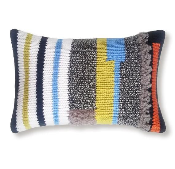 a multicolored striped pillow on a white background