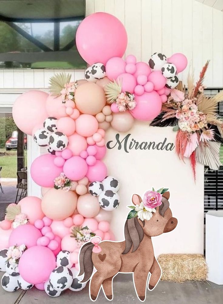 there is a pink and black balloon arch with a pig on it