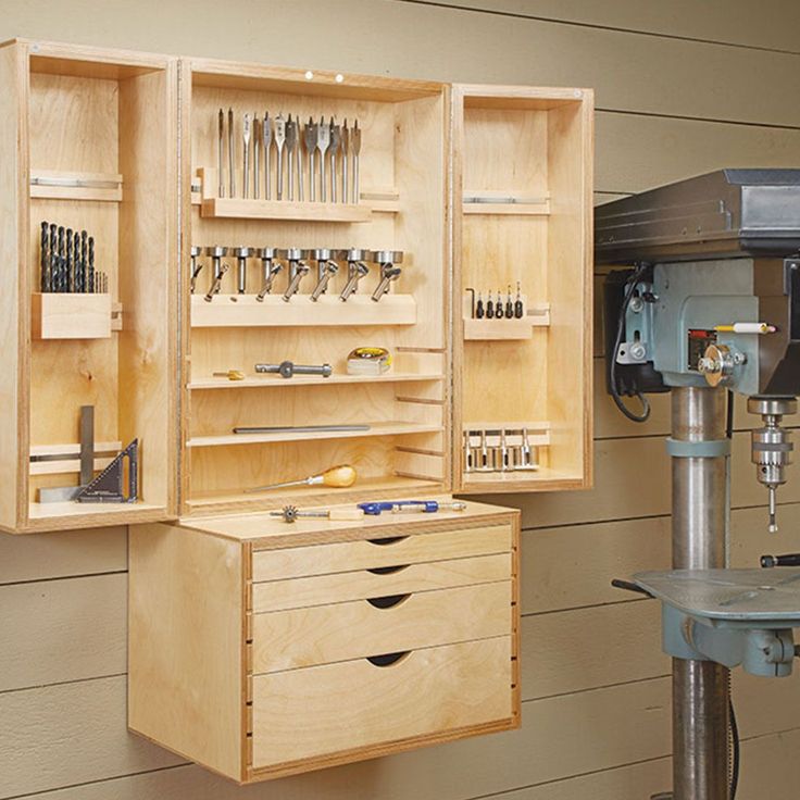 a workbench with many tools in it on the wall next to a driller