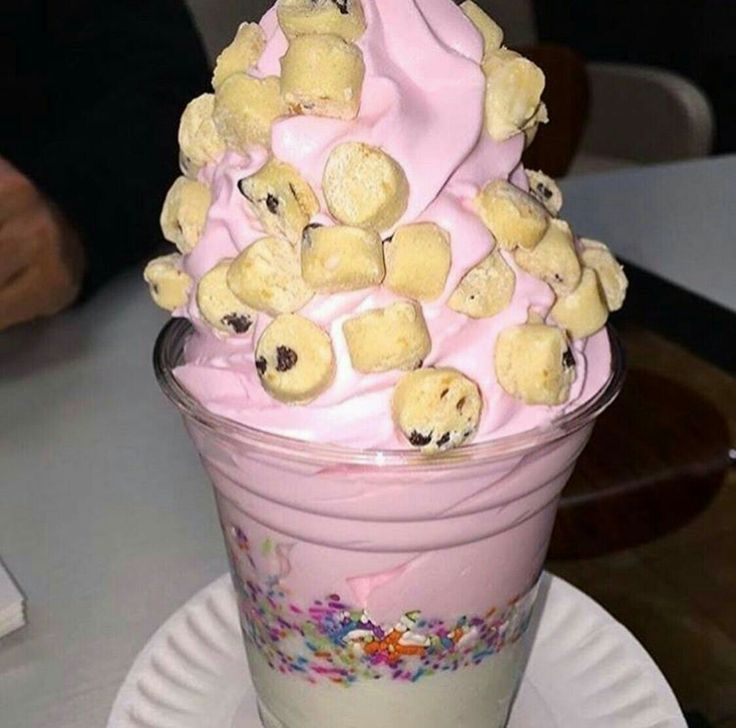 a cup filled with ice cream covered in teddy bears and sprinkled with pink frosting