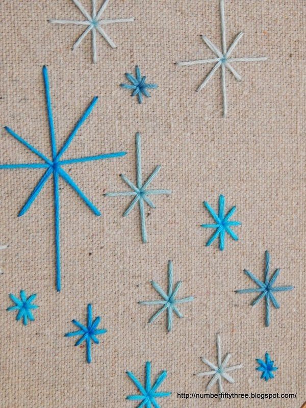 blue and white snowflakes are on a piece of fabric next to scissors