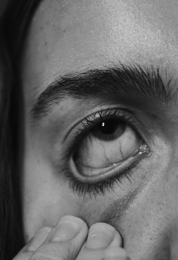 a close up of a person's eye with their finger in the iris area