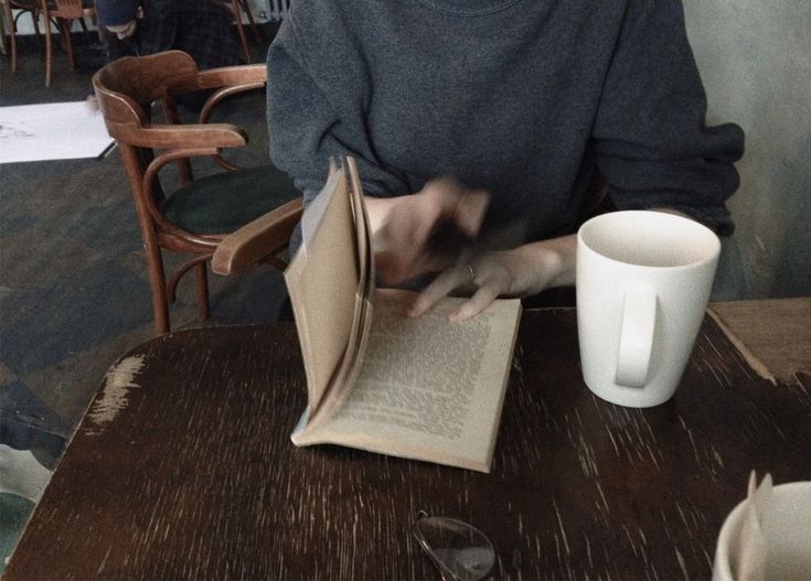 a person sitting at a table with an open book