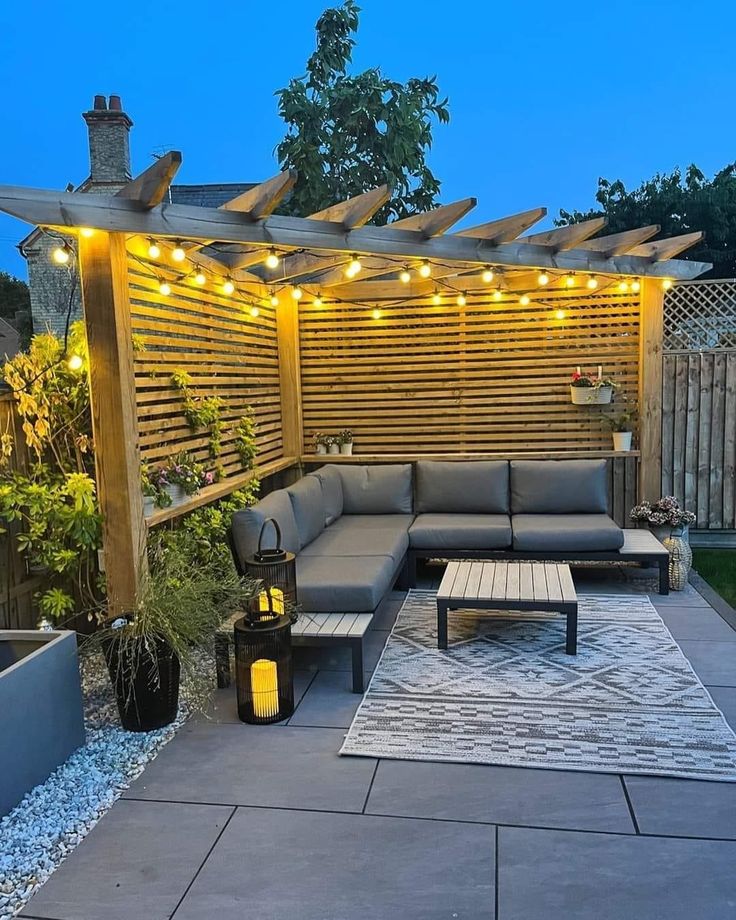 an outdoor living area with patio furniture and string lights on the pergolated roof