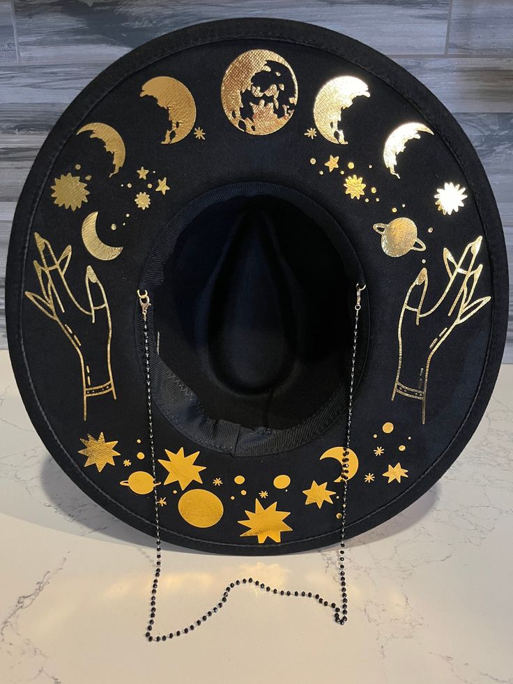 *due to printing there might be slight placement differences than pictured. A sturdy thick 100% polyester hat. I have applied moons and a cosmic theme in a gold metallic film. This hat has a detachable chain. Get your witchy vibe on. It has adjuster inside. Size S/M 22.3 inch circumference Size M/L 22.8 inch circumference and 3.25 inch brim. Has inside adjuster. Cosmic Witch Hat, Lunar Witch Hat, Wide Brim Witch Hat, Painted Witch Hat, Cosmic Witch Costume, Eclectic Witch Outfit, Moon Themed Clothes, Cosmic Witch Outfit, Halloween Clothes Aesthetic