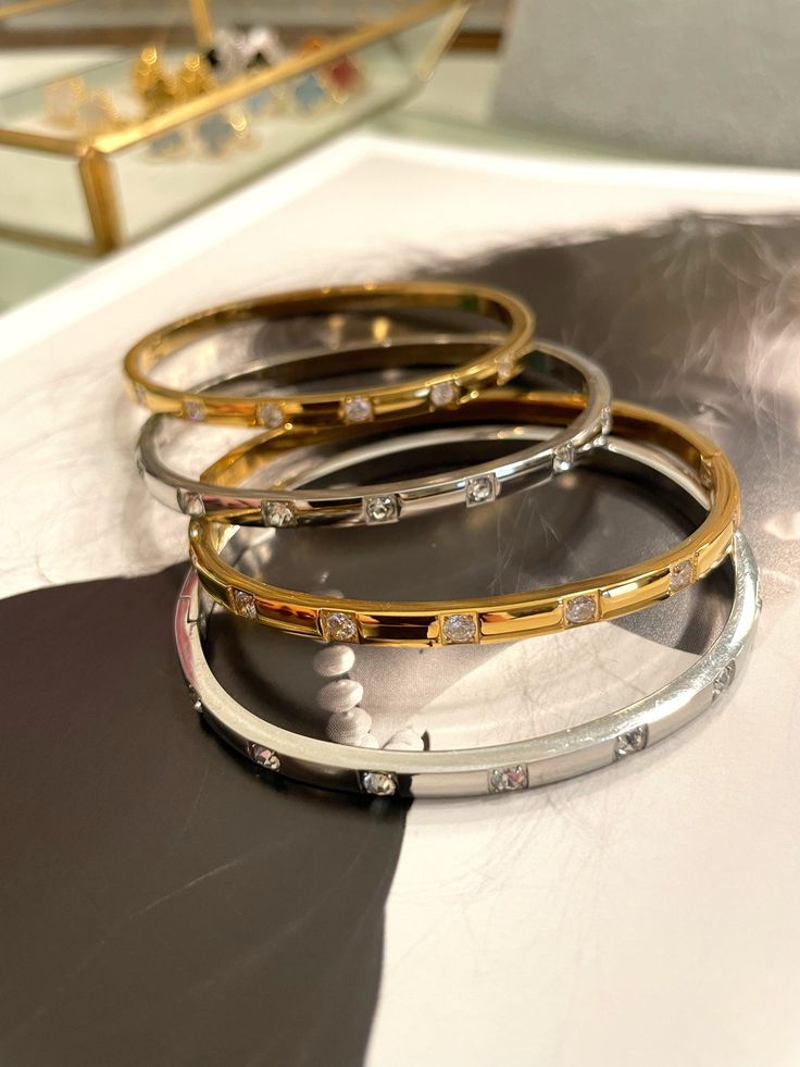 These chic bangles are crafted with fine details, featuring sparkling zircon and luxurious gold plating. Add a touch of elegance to any outfit and stand out from the crowd. Upgrade your style with Emma Bracelets today! Elegant Stackable Gold Bracelet With Cz, Elegant Stackable Gold Bracelet With Cubic Zirconia, Elegant Stackable Cubic Zirconia Bangle, Elegant Cubic Zirconia Stackable Bangle, Gold-plated Bangle Bracelets With Diamond Accents, Elegant Party Bangle With Diamond Accents, Elegant Cuff Bracelet With Sparkling Stones, Elegant Bangle Cuff Bracelet With Sparkling Stones, Elegant Gold Bracelets With Sparkling Stones