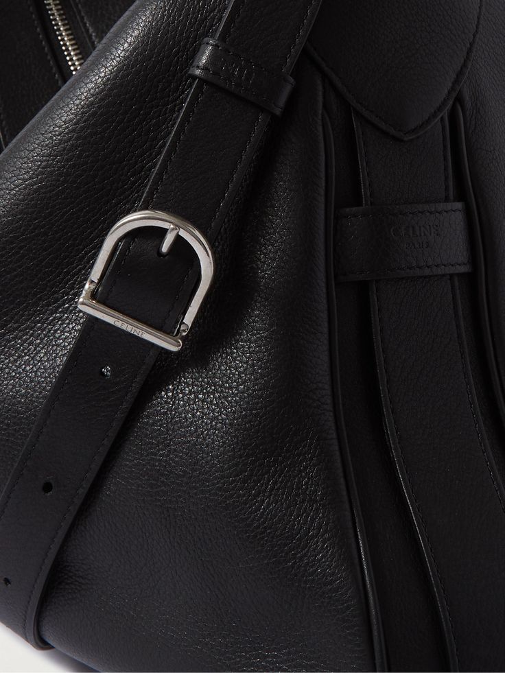 CELINE HOMME's expertise in leather goods dates back to 1966. This 'Romy' messenger bag is crafted from supple textured hide and has a distinctive curved top and adjustable strap. It's large enough to carry the essentials, as well as a book and a change of clothes. Luxury Business Crossbody Backpack, Formal Leather Backpack With Detachable Strap, Formal Shoulder Bag With Detachable Strap, Designer Leather Backpack With Top Handle, Luxury Leather Satchel Backpack For Work, Luxury Soft Leather Satchel Backpack, Leather Backpack With Detachable Strap For Business, Formal Satchel Backpack With Adjustable Strap, Luxury Leather Backpack With Palladium Hardware