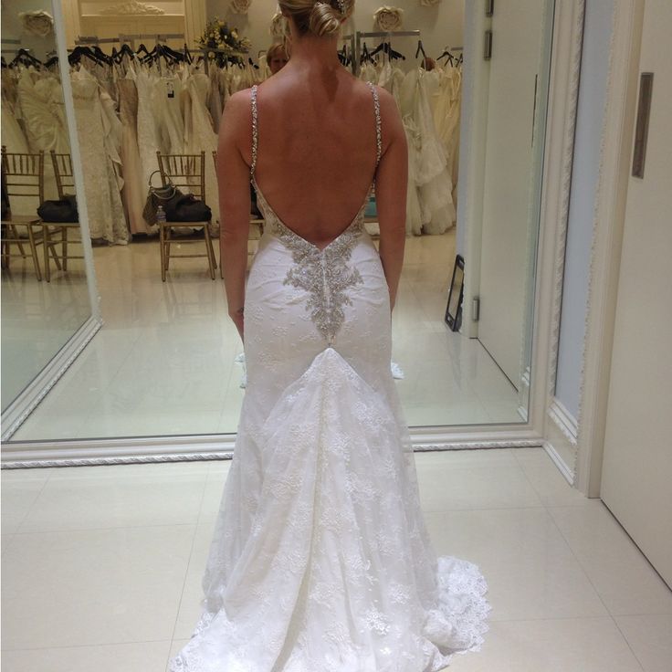 the back of a woman's wedding dress in front of a mirror