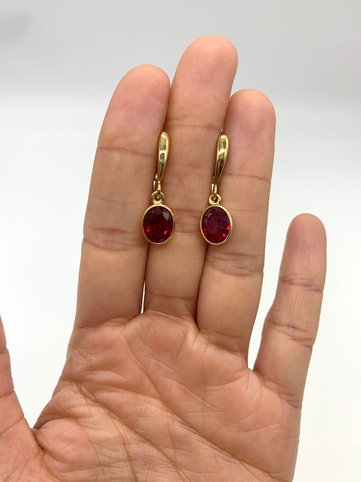 Ruby Drop Earrings set with a Created Ruby in a flawless clarity & stunning red color, at 10x8mm each (6 Cts a pair).  Gold Vermeil: 18k Gold over Solid 925 Sterling Silver ☞ made to last. Matching Ring: www.etsy.com/listing/1610535967 Matching Pendant: Please ask me Details :  ♥ Each item comes in a cute GIFT BOX ✓  ♥ GUARANTEE on the materials ✓ ♥ Created Ruby in a flawless clarity ✓ ♥ Gold Vermeil: Thickest 3 Micron Gold plate on Solid 925 Sterling Silver ♥ Measurements: Ruby size at 10x8mm each, 6 Cts a pair ✓ ♥ Each stone is set professionally - Real Jewelry artisan work ♕ ♥ More Beautiful jewellery on www.etsy.com/shop/AdinaStone ☜    ✉ Shipping by Royal Mail ✉ Tracked Shipping Option - worldwide tracking - choose at checkout: U.K. 1 Day delivery !  USA & Worldwide ✈ 5-7 Days  Standa Red Ruby Single Earring, Single Ruby Earring In Red, Red Single Earring For Formal Occasions, Red Clip-on Earrings For Anniversary, Red Oval Ruby Earrings, Ruby Earrings With Ear Wire For Gift, Ruby Earrings With Ear Wire As Gift, Red Oval Earrings For Pierced Ears, Red Round Clip-on Jewelry