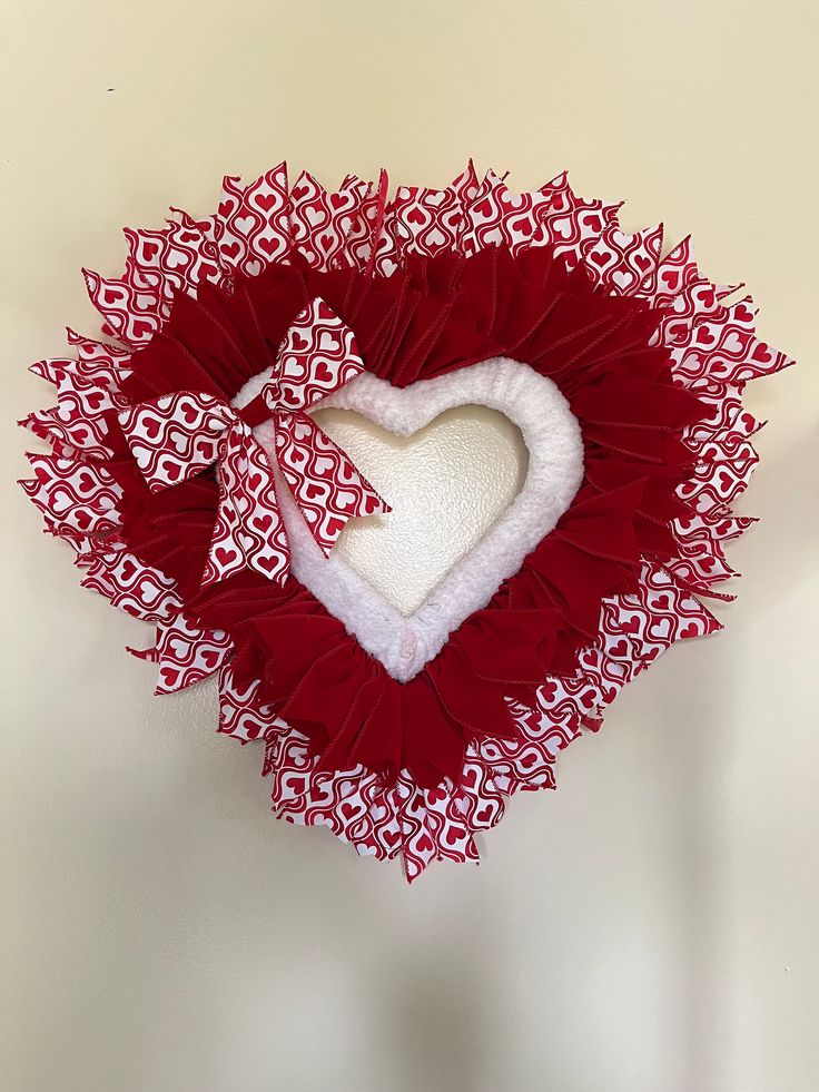 a red and white heart decoration hanging on the wall