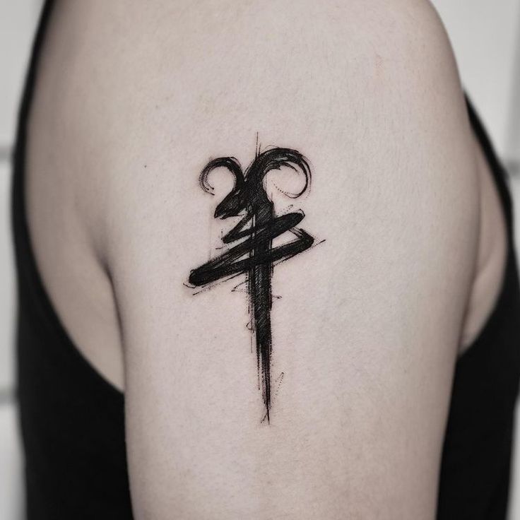 a cross tattoo on the back of a woman's shoulder