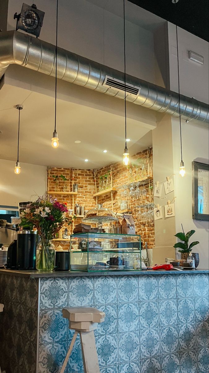 the interior of a restaurant with blue tiles and lights hanging from it's ceiling