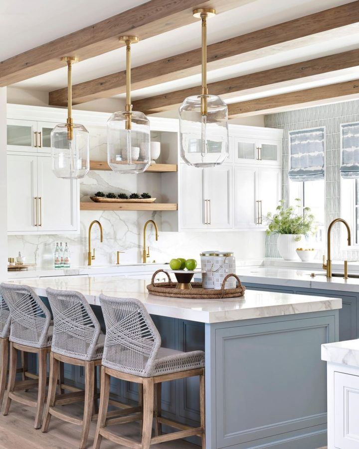 a kitchen with white cabinets and gray chairs