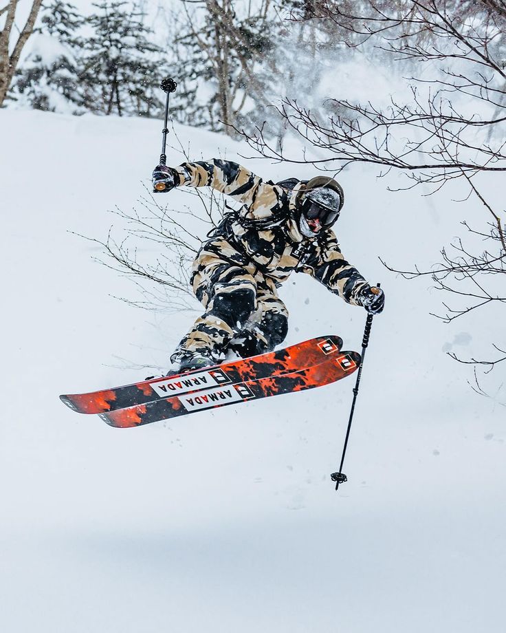 a man flying through the air while riding skis on top of snow covered ground