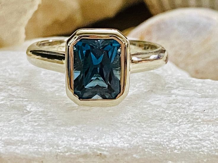 This classic bezel ring contains a 2.00 ct. natural radiant cut London blue topaz. The center stone measures 8x6mm . The ring is available in sterling silver, and 14k white, yellow or rose gold. The mounting is a modern, elegant setting with a high polish finish. Please send me a message if you need a size not listed. This ring can also be customized with any color center stone. All items are handmade by me in my shop in Manalapan, NJ. Please message me with any questions. Shipping within the Un London Blue Topaz Engagement Ring, Engagement Ring Bezel, London Blue Topaz Engagement Rings, Cathedral Engagement Rings, Blue Topaz Engagement Ring, Bling Ring, Bezel Engagement Ring, Future Engagement Rings, Moissanite Engagement Ring Solitaire