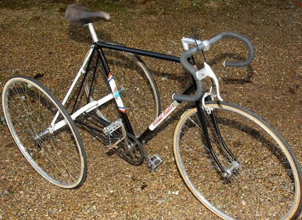 a black and white bike parked on top of a gravel road