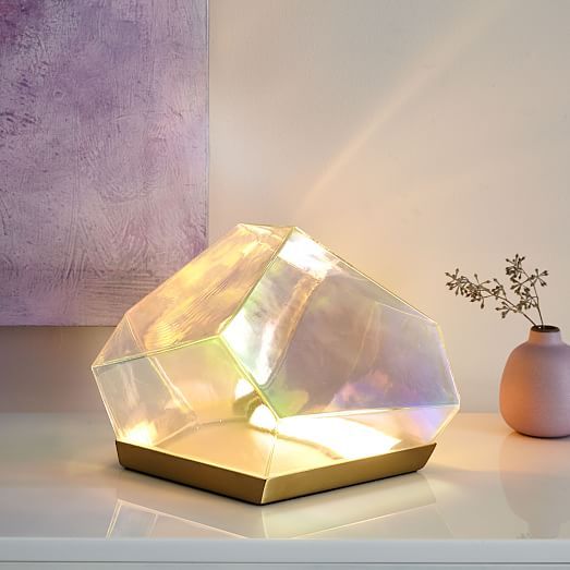 a glass vase sitting on top of a table next to a small white flower pot