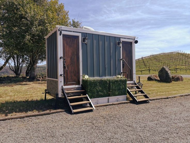 a tiny house made out of shipping containers on the side of a road with steps leading up to it