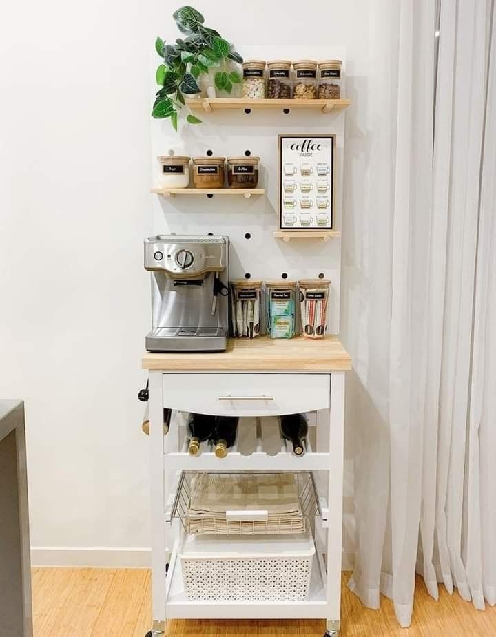 a small kitchen island with shelves on the wall and coffee maker in front of it