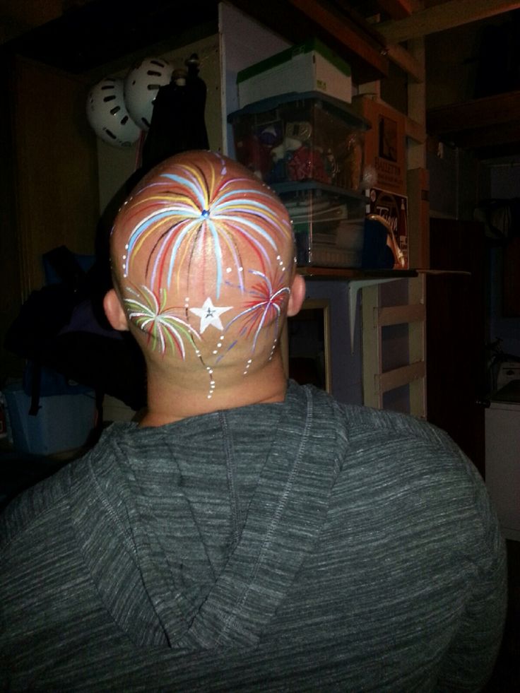 a man with fireworks painted on his face in the middle of a dark room,