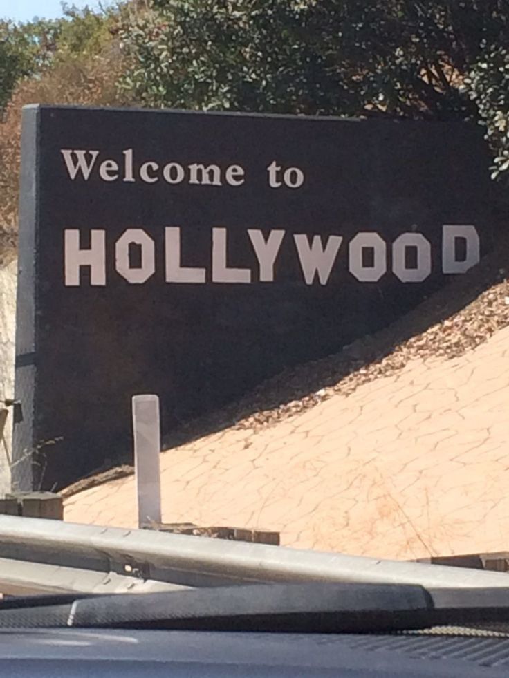 a welcome sign to hollywood on the side of a road