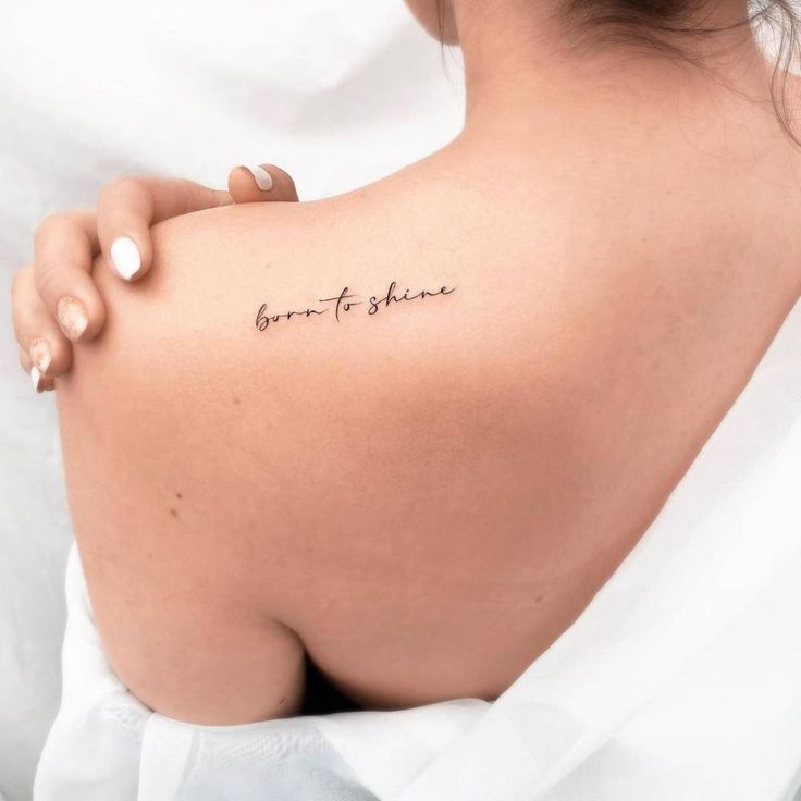 the back of a woman's shoulder with a tattoo saying born to shine on it