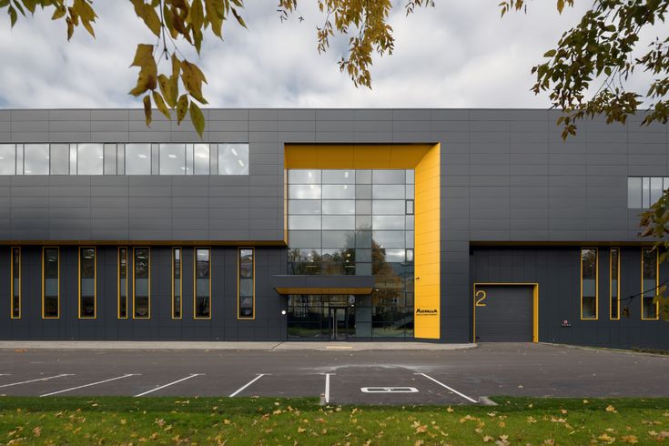 an empty parking lot in front of a building with yellow and grey doors on it