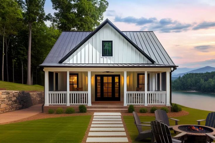 a white house with two chairs and a fire pit in the front yard next to it