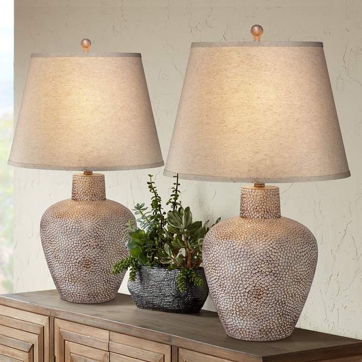 two vases sitting on top of a dresser next to each other with a plant in the middle