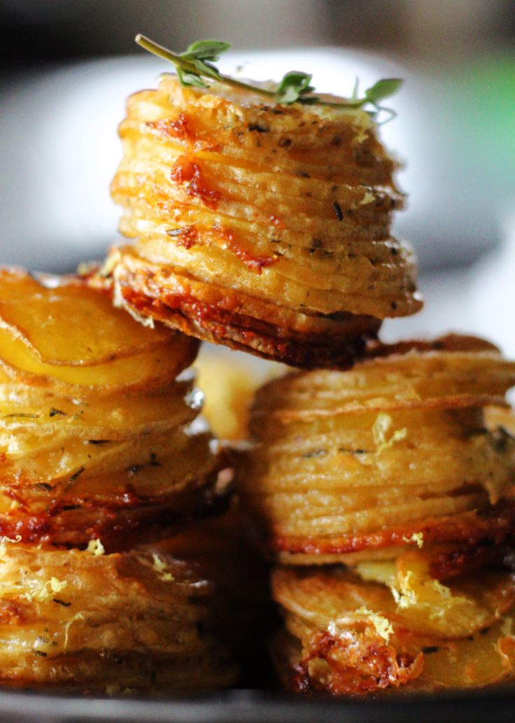 some food is stacked on top of each other in a black bowl and garnished with herbs