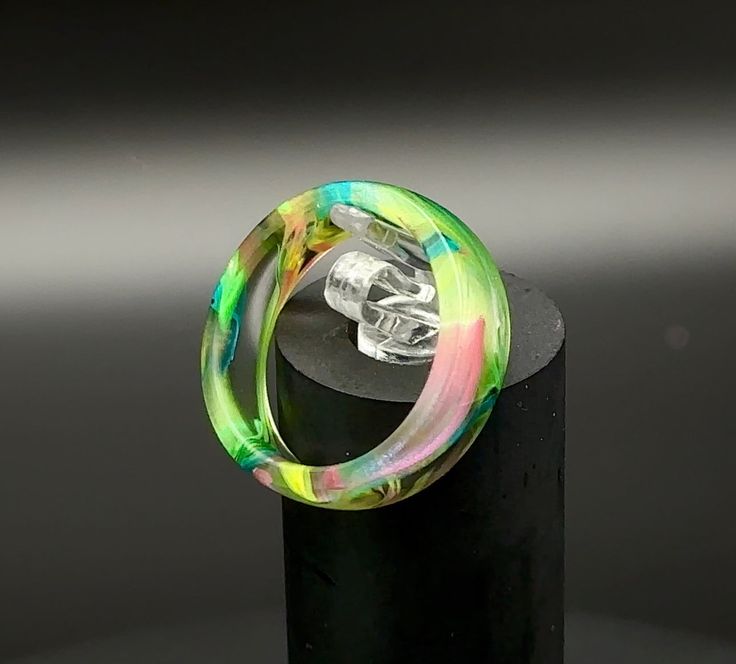 Are bright neon colors your thing?? Swirling with shades of bright neon colors, this ring is bold! These rings do not glow in the dark, but they will light up and come alive when exposed to UV light. These rings are hand cut from epoxy resin cores. Because of the variances in each core from end to end, each ring will be unique and one of a kind. The base ring can be worn just as it is or you can add one of several liners to set it off and take it to the next level. Check out our ring liners for Bark At The Moon, Floral Ice, Redwood Burl, Set It Off, Buckeye Burl, Custom Gift Cards, Memorial Ring, Matching Wedding Bands, Resin Ring