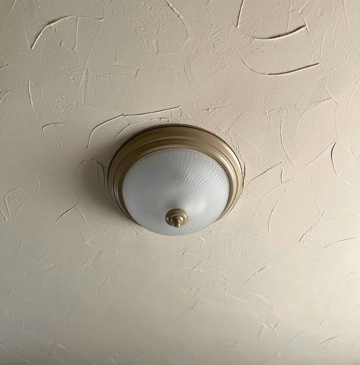 a light that is on the side of a wall in a room with white walls