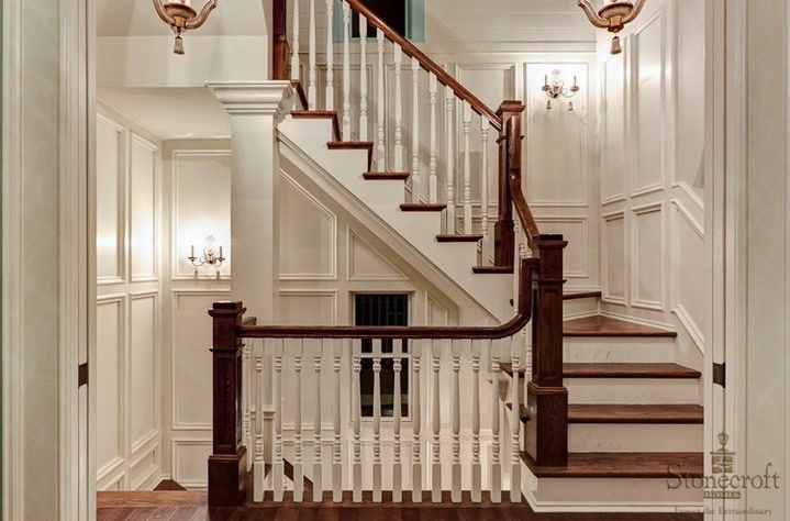 a black and white photo of a staircase with chandeliers on either side of it