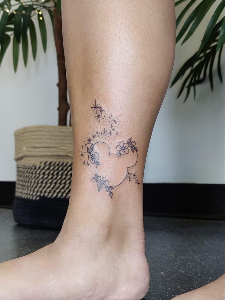 a woman's foot with a small tattoo on the side of her leg and stars