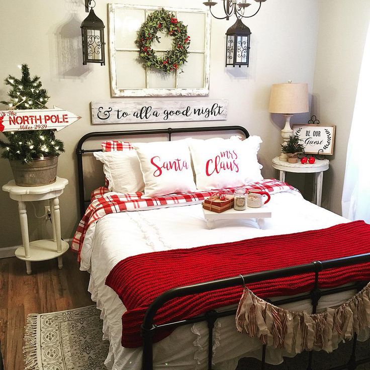 a bedroom decorated for christmas with red and white bedding, wreaths on the wall